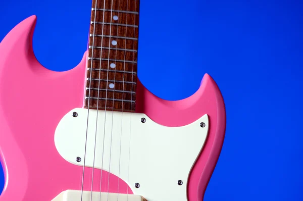Guitarra eléctrica rosa aislada en azul — Foto de Stock