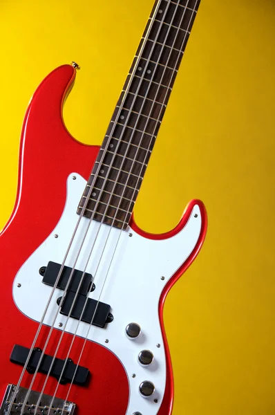 Rode elektrische gitaar geïsoleerd op geel — Stockfoto