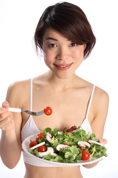 Chica sonriente comiendo comida de ensalada — Foto de Stock