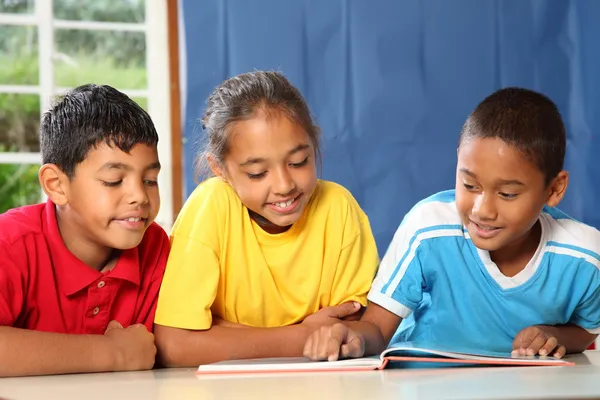 Três amigos da escola primária leitura e aprendizagem — Fotografia de Stock
