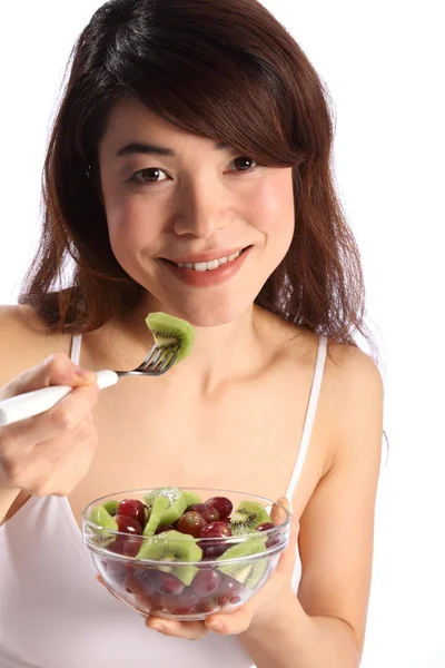 Oriental menina comendo tigela de frutas — Fotografia de Stock