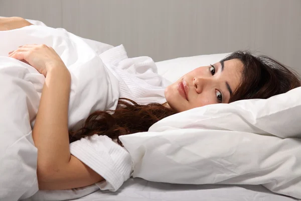 Woman lying in bed eyes open — Stock Photo, Image