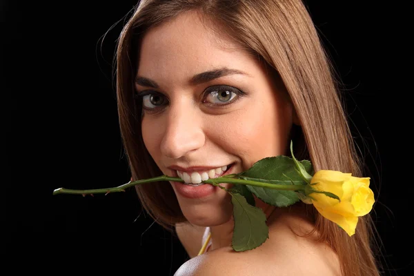 Kvinna med gul ros i munnen — Stockfoto