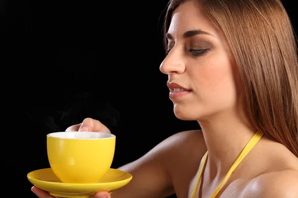 Γυναίκα με κίτρινο τσάι Κύπελλο και πιατάκι — Φωτογραφία Αρχείου