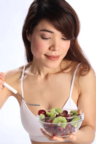 Schöne Frau isst Kiwi und Weintrauben — Stockfoto