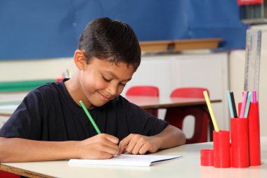 Genç okullu çocuk 10 sınıf masasında yazma