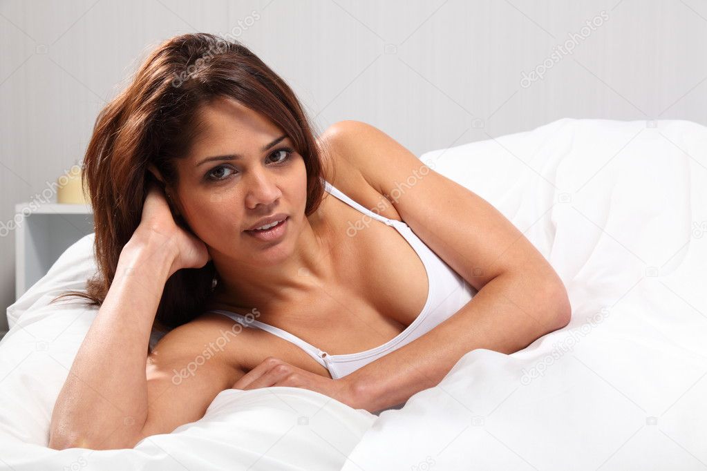 Young woman propped up in bed
