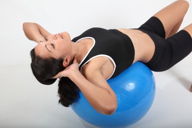 Fit woman workout on exercise ball clipart