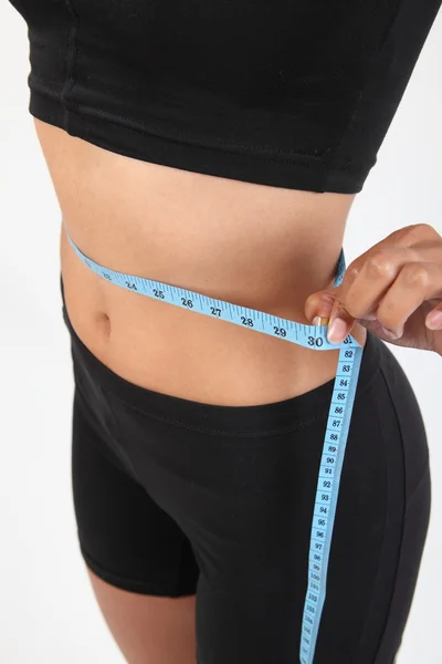 Mulher magro com uma fita métrica em torno de sua cintura — Fotografia de Stock