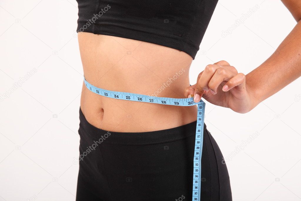 Measuring waist of sportswoman with tape measure stock photo