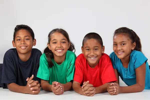 Lächelnde Schulkinder auf dem Boden — Stockfoto