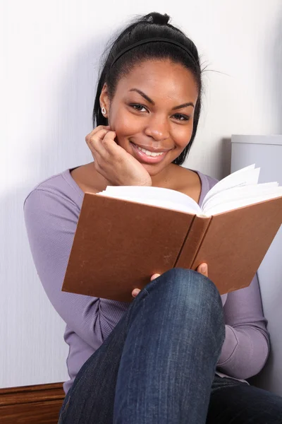Menina africana feliz bonita lendo um livro — Fotografia de Stock