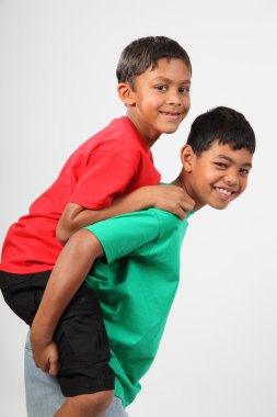 Playful young school mates giving piggy back clipart