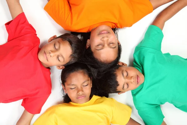 Vier Kinder, die vorgeben zu schlafen — Stockfoto