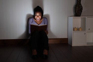 genç kadın evde hayalet kitap okuma çığlık atıyor