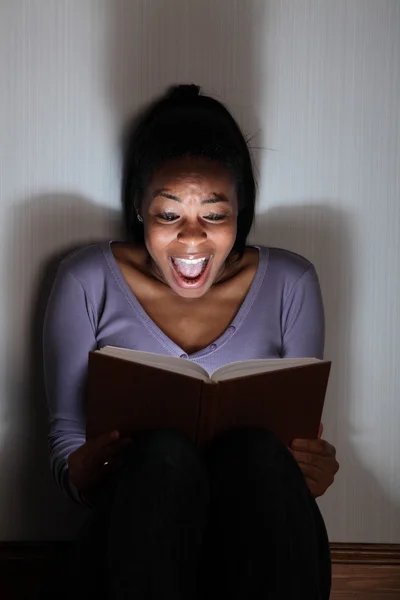 Junges Mädchen schreit beim Lesen eines gruseligen Märchenbuchs — Stockfoto
