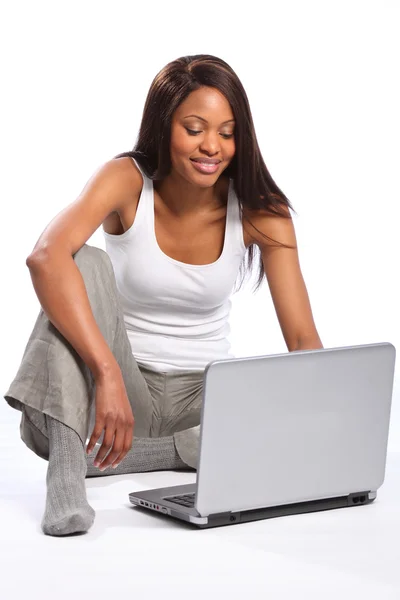 Μαύρη γυναίκα στο πάτωμα χρησιμοποιώντας φορητό υπολογιστή — Φωτογραφία Αρχείου
