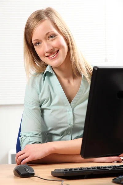 Belle femme blonde heureuse à l'ordinateur de bureau — Photo