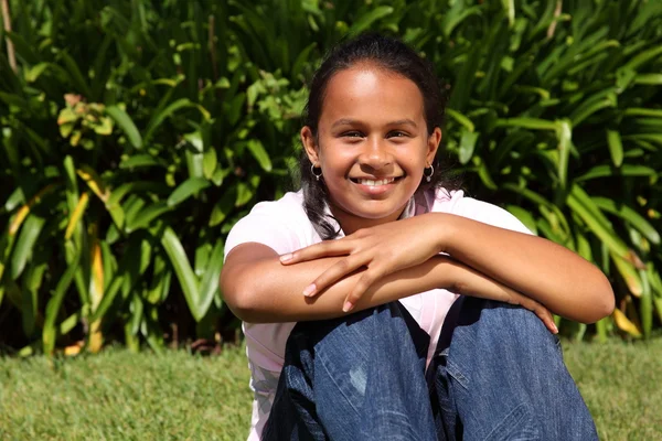 Sonriente chica con rodillas en la hierba — Foto de Stock