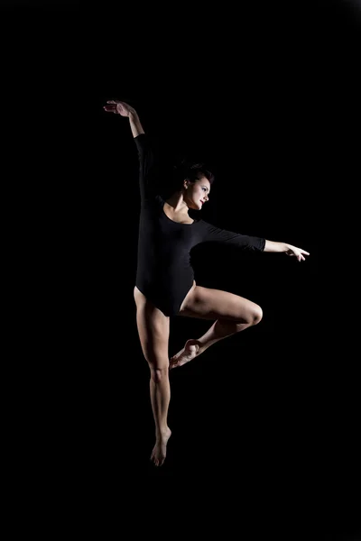 Mladá žena gymnastka pozastaveno pozice — Stock fotografie
