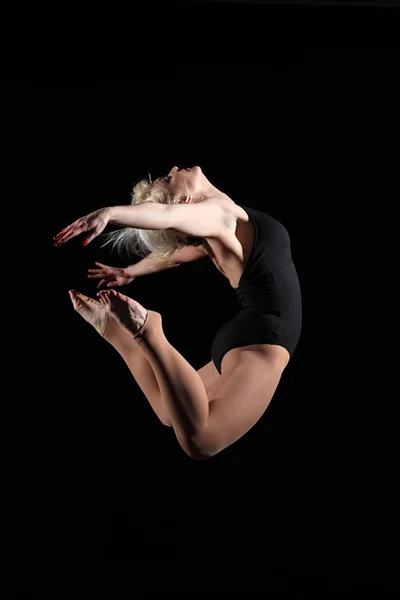 Jonge vrouw gymnast geschorst pose — Stockfoto