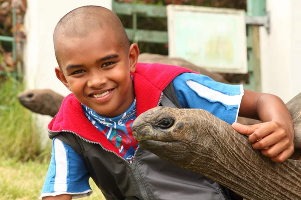 Улыбающийся мальчик с гигантской черепахой — стоковое фото