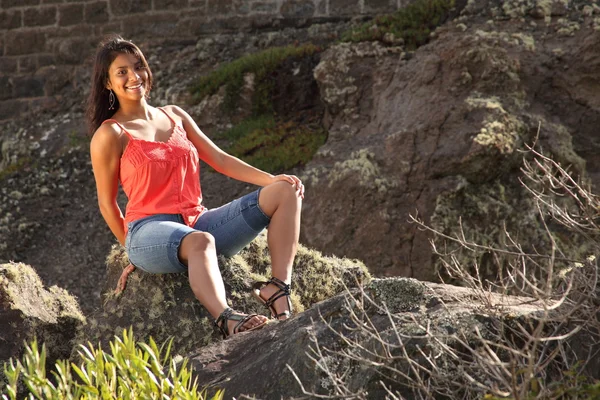 Junges Mädchen sitzt auf einem Felsen — Stockfoto