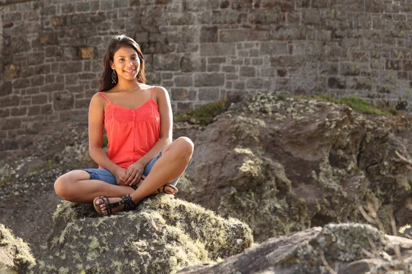 Ładna dziewczyna siedzi na skale — Zdjęcie stockowe
