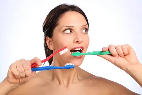 Joven divertida con tres cepillos de dientes —  Fotos de Stock