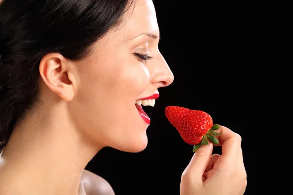 Beautiful happy woman eating red strawberry fruit — Stock Photo, Image