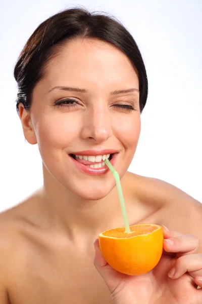 Красивая молодая женщина пьет сок из апельсина — стоковое фото
