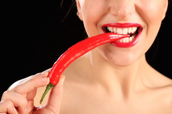 Bela boca de mulheres mordendo pimenta vermelha — Fotografia de Stock