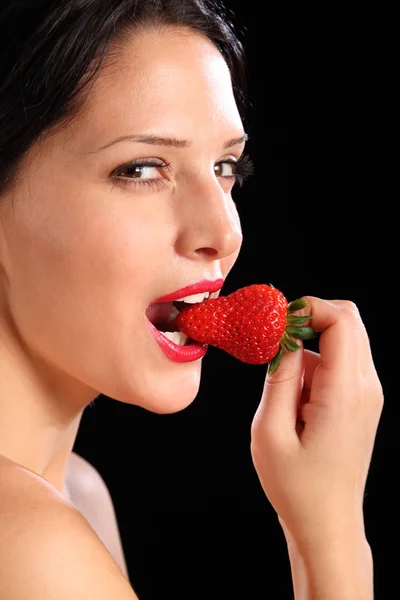 Сексуальный взгляд женщины, которая ест свежие клубничные фрукты — стоковое фото