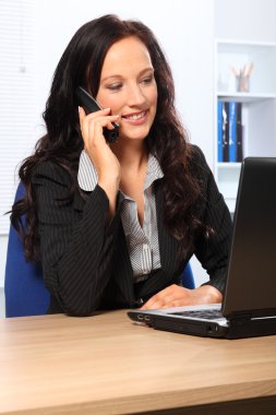 Beautiful business woman using telephone at work clipart