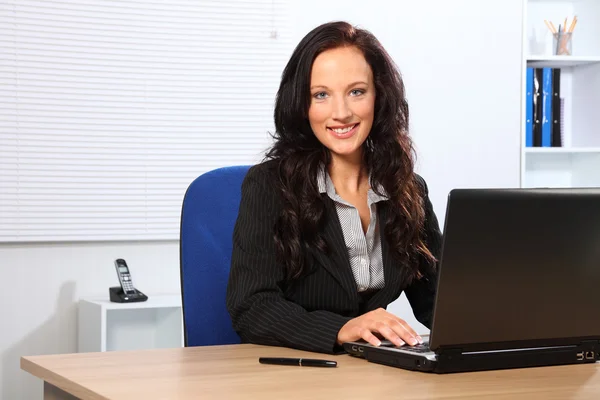 Όμορφη χαμογελαστό γυναίκα χρησιμοποιώντας φορητό υπολογιστή στο γραφείο — Φωτογραφία Αρχείου