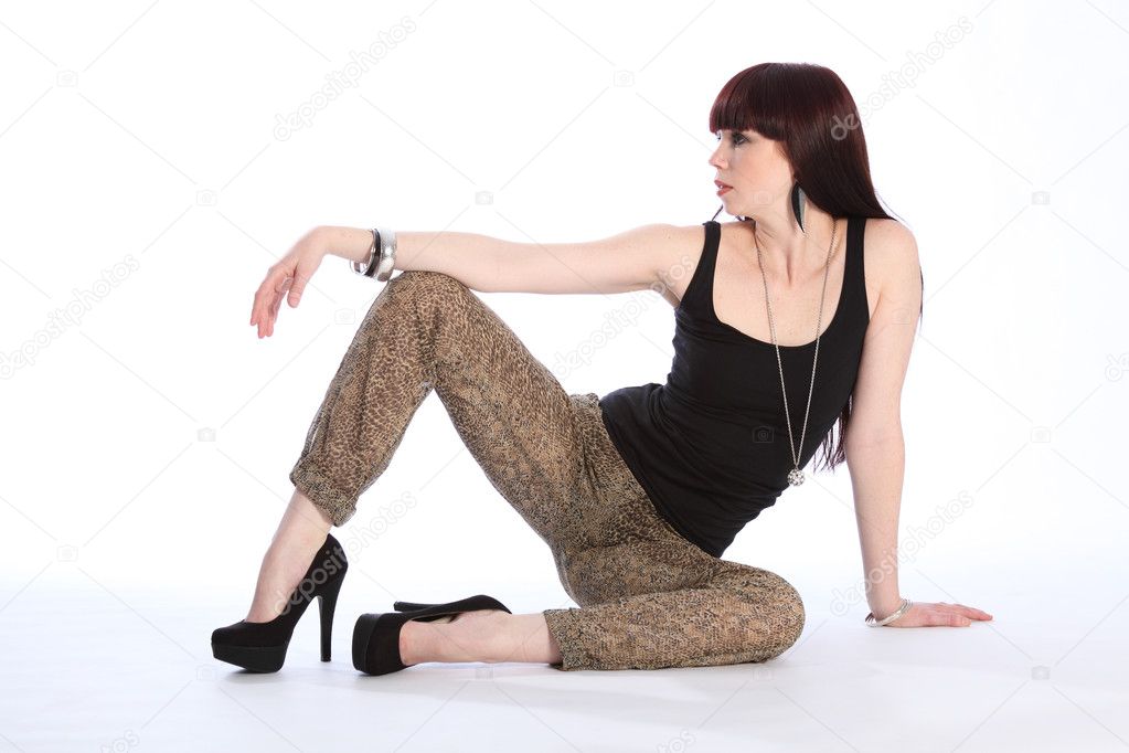 Sexy leggy fashion model sitting on floor
