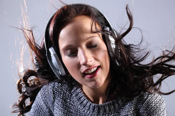 Mulher bonita ouvindo música em fones de ouvido — Fotografia de Stock