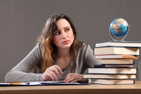 Controllare il globo una ragazza adolescente che fa i compiti — Foto Stock