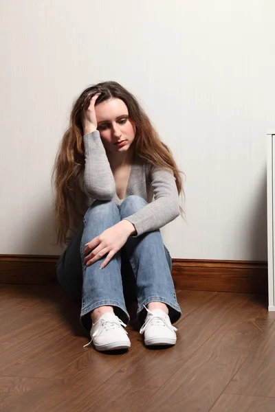 Depressiv und allein sitzt ein Teenager-Mädchen auf dem Boden — Stockfoto