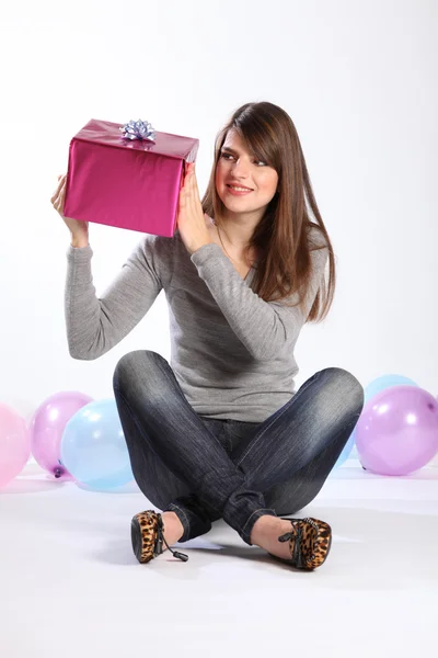 Vacker ung flicka som är nyfiken på födelsedagspresent — Stockfoto