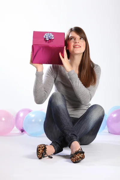 Красивая девушка угадывает загадочный подарок на день рождения — стоковое фото