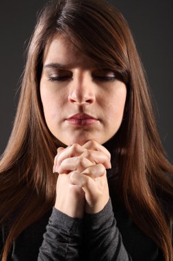 Religious woman eyes closed hands clasped praying clipart