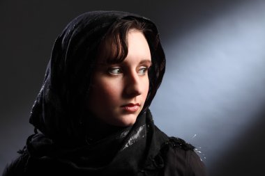 Beautiful young woman wearing headscarf in church clipart