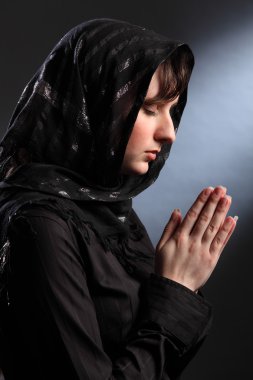 Beautiful woman in headscarf praying eyes closed