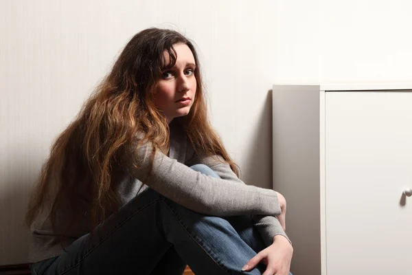 Tonårsflicka deprimerad sitter på golvet hemma — Stockfoto
