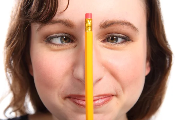 Fun moment as girl holds pencil between her eyes — Stock Photo, Image