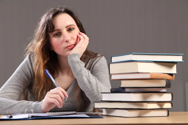 Stanco studente ragazza seduta a scrivania facendo i compiti — Foto Stock