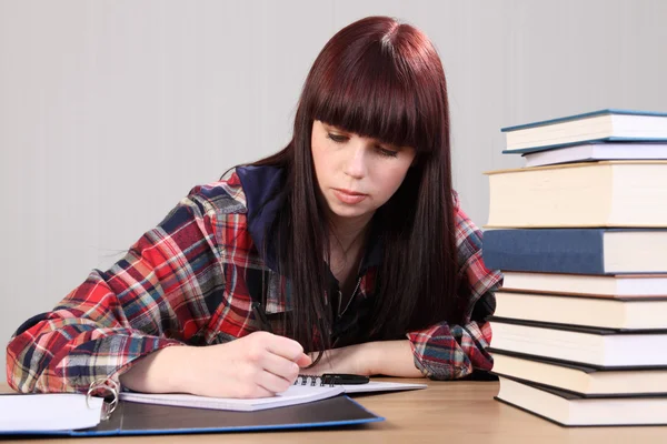 Mladý student dívka dělat domácí úkoly, zápis v knize — Stock fotografie