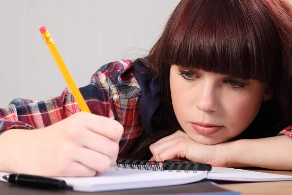 Yoğun öğrenci kız ev ödevi kalemle yazma — Stok fotoğraf