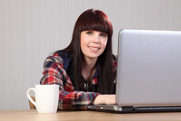 Hermosa estudiante feliz haciendo la tarea en el ordenador portátil —  Fotos de Stock